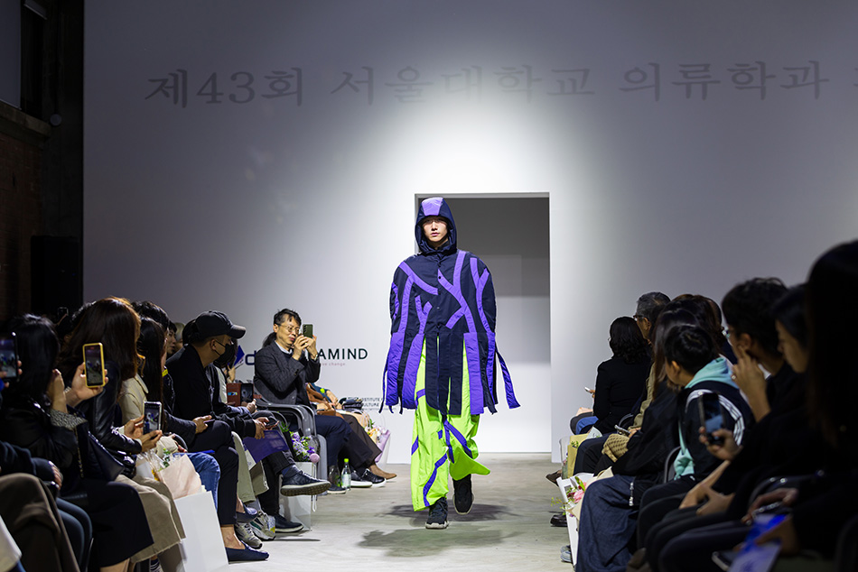 A model showcases a striking, multi-colored garment.