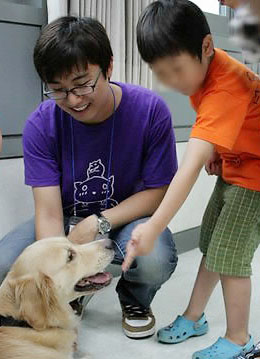 A kid is making friends with a dog with the help of Ryu.