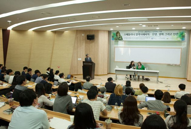 The lecture room was filled with students and some of them had to sit on the floor.