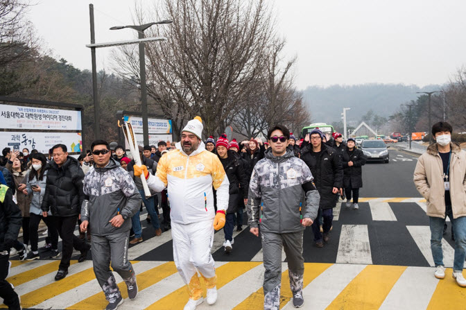 The torchbearers and students are running across the campus